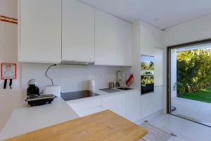 a kitchen with white cabinets and a counter top at Morada do Sol with Private Pool & Garden in Alvor +31 photos