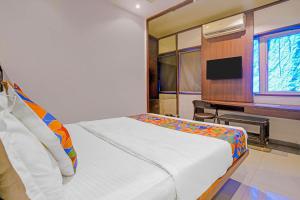 a bedroom with a bed and a desk and a television at FabHotel Dukes Plaza in Ulhāsnagar
