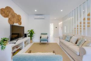 a living room with a couch and a tv at Morada do Sol with Private Pool & Garden in Alvor