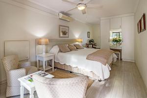 a bedroom with a bed and a table and chairs at Majorca House in Somerset West +46 photos