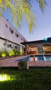 a house with a swimming pool in front of it at Hotel Teofilo Otoni in Teófilo Otoni