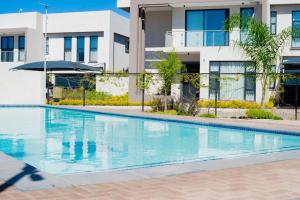 a swimming pool in front of a building at The Captains Suite in Gaborone