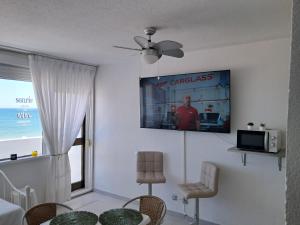 a living room with a tv on the wall at Apartahotel Estudio 221 in Matalascañas