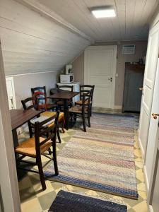 a dining room with wooden tables and chairs and a rug at Charlottenlunds Gårdshotell & Restaurang in Långaryd +12 photos