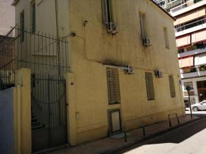 a building with a gate on the side of a street at Courtyard Cottage in Athens