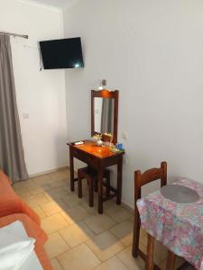 a small room with a table and a mirror at Odysseus Apartments in Agios Gordios