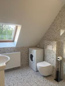 a bathroom with a washing machine and a toilet at Zaczarowany Bieślin in Trzemeszno +38 photos