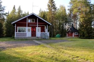 ein kleines rotes Haus mit Garage im Hof in der Unterkunft Ahosen Lomamökit in Vikajärvi
