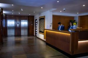 two women standing at a reception desk in a hotel lobby at Almacruz Hotel y Centro de Convenciones (Ex Galerías) in Santiago
