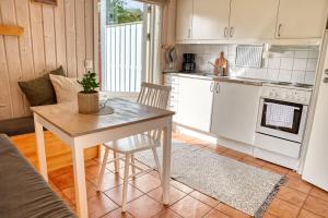 a kitchen with a table and a kitchen with a stove at Apelvikens Camping & Cottages in Varberg