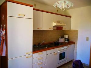 a kitchen with white cabinets and a sink at Ferienwohnung Meyer in Schönwald