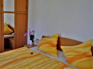 a bedroom with a bed with yellow and orange pillows at Ferienwohnung Meyer in Schönwald
