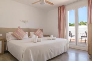 a bedroom with a large white bed with a balcony at Hostal La Llagosta in Llafranc +14 photos