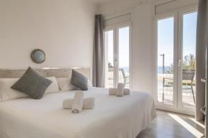 a bedroom with a large white bed with a large window at Hostal La Llagosta in Llafranc