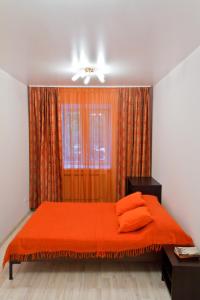 エカテリンブルクにあるApartment Allis-hall on Malysheva 73 Aのベッドルーム1室(オレンジ色のベッド1台、窓付)