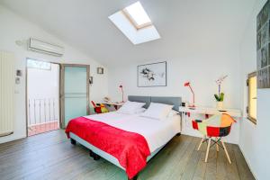 a bedroom with a bed and a table and a chair at Le Limas in Avignon