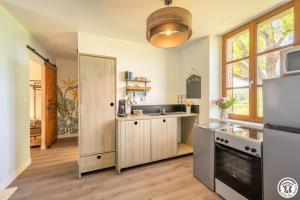a large kitchen with a sink and a stove at Le cadre in Bonnières