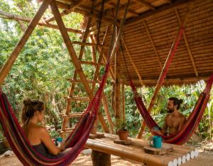 a man and a woman sitting in hammocks in a tent at Ecocio Explorations in Coron +42 photos