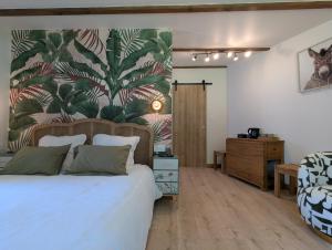 a bedroom with a large bed with a tropical wallpaper at l'Orée du Bois in Saint-Brice