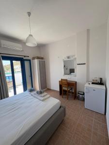 a bedroom with a bed and a desk and a television at Keramos in Loutro