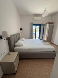 a large bed in a room with a window at Keramos in Loutro