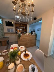 a dining room table with plates of food and a chandelier at Hotel Juan Pablo 2 in Ríohacha +29 photos