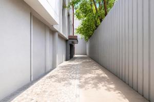 an alleyway between two buildings with trees on either side at FabHotel Prasad International in Mumbai