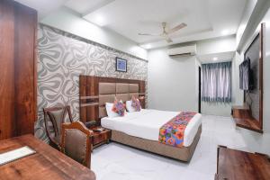 a bedroom with a bed and a desk and a chair at FabHotel Prasad International in Mumbai +31 photos