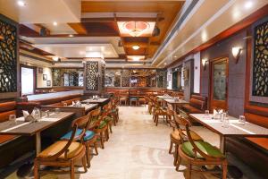 a restaurant with wooden tables and chairs at FabHotel Prasad International in Mumbai