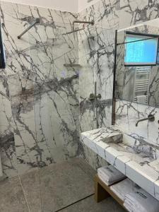 a bathroom with a marble shower with a sink at Oliveto Apartments in Riva del Garda +26 photos