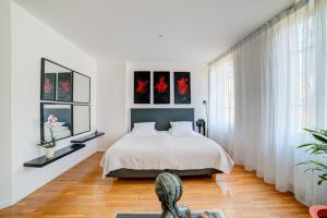 a bedroom with a bed and a large window at Le Limas in Avignon