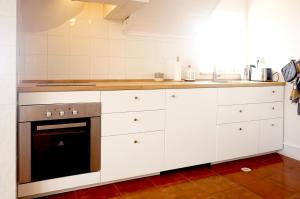 a kitchen with white cabinets and an oven at Old Town Apt with Ocean Views in Sesimbra