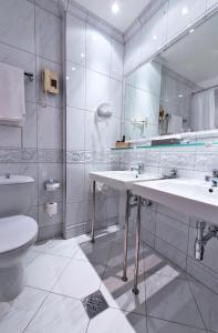 a bathroom with two sinks and a toilet and a mirror at Hotel König von Ungarn in Vienna