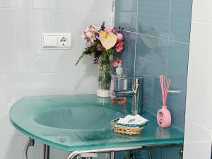 a glass sink with a vase of flowers on it at casa muralla - plaza mayor in Ciudad-Rodrigo +19 photos