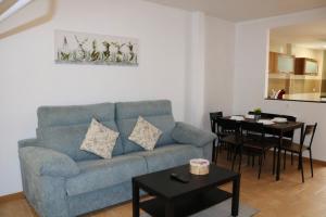 a living room with a blue couch and a table at casa muralla - plaza mayor in Ciudad-Rodrigo