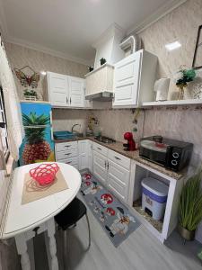 a kitchen with white cabinets and a table and a counter at Moradia Ricardo - Nazaré in Nazaré