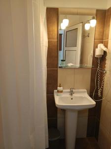 a bathroom with a sink and a mirror at Odysseus Apartments in Agios Gordios +29 photos