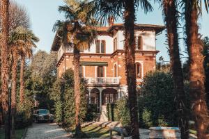 an old house with palm trees in front of it at Villa Evelina in Travedona