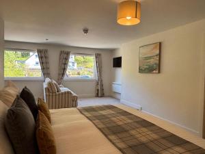a room with a bed and a couch and a chair at Harbour House in Ullapool