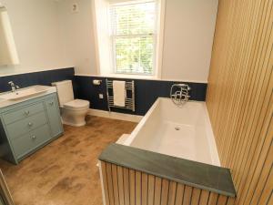 a bathroom with a tub and a toilet and a sink at East View in Kirkby Stephen +26 photos
