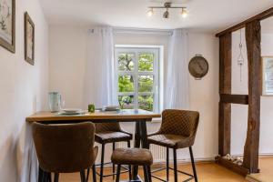 a dining room table with chairs and a window at Dommelhof Ferienwohnungen in Diemelsee