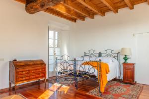 a bedroom with a bed and a dresser and a window at Villa La Limonera in Casciago