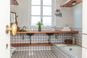 a bathroom with a tub and a sink and a tubermottermott at Villa La Limonera in Casciago