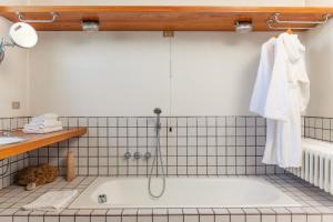 a bath tub with a shower in a bathroom at Villa La Limonera in Casciago