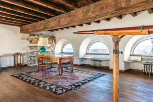 a room with a table and chairs and two windows at Villa La Limonera in Casciago
