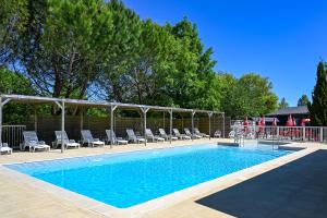 a large swimming pool with chairs at Camping les Coteaux du Lac in Chemillé-sur-Indrois