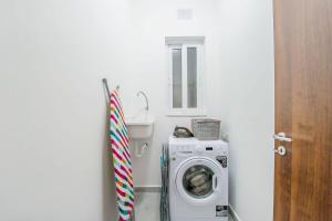 a washer and dryer in a bathroom with a washing machine at Hillock Residence Marsalforn in Marsalforn