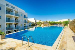 a large swimming pool in front of a building at Hillock Residence Marsalforn in Marsalforn