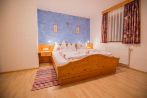 ein Schlafzimmer mit einem Holzbett in einem Zimmer in der Unterkunft Haus Alpengruss in Neustift im Stubaital