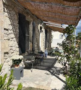 a patio with a table and chairs and a building at Maison Cerise in Arles